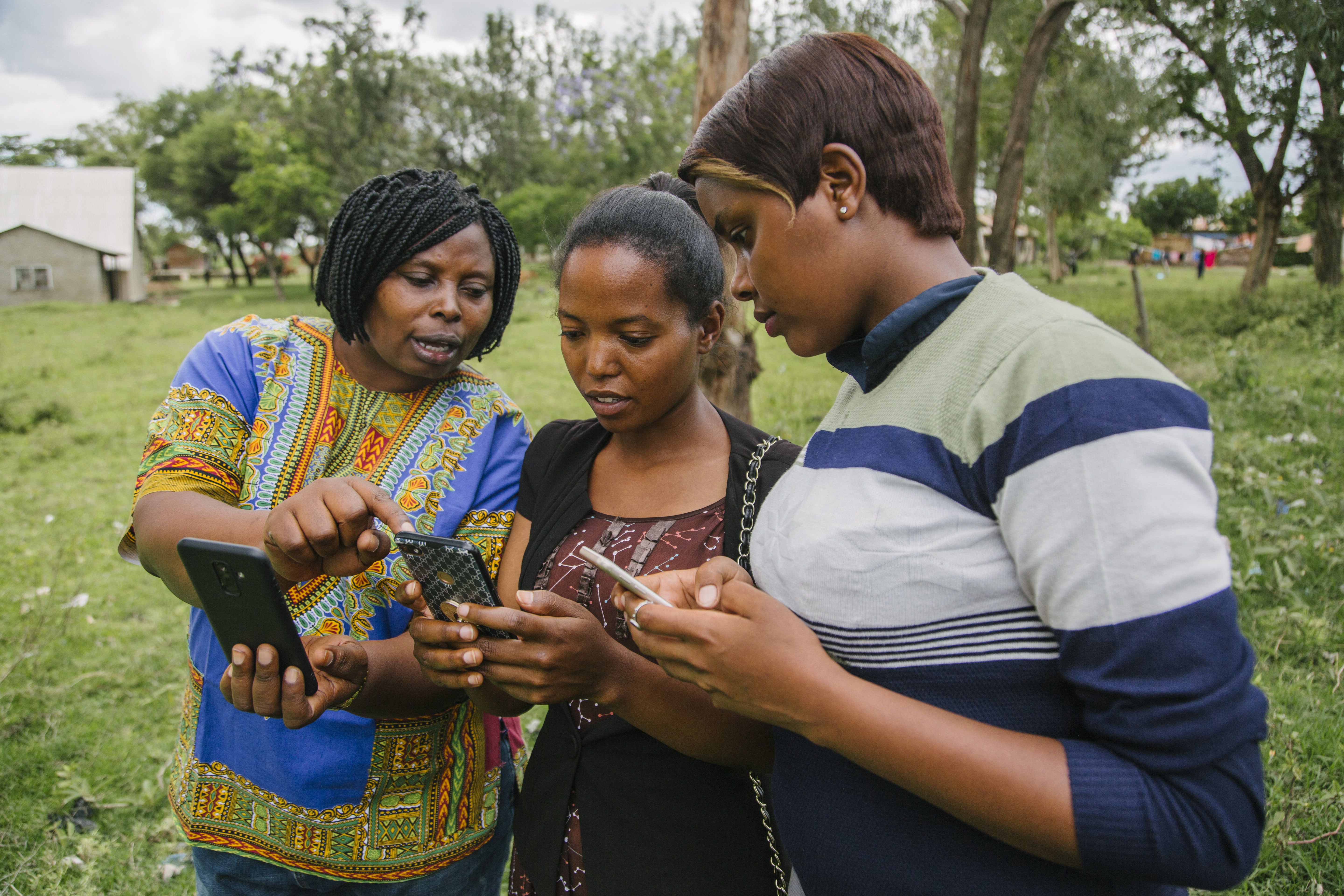 December 14, 2018: Mugumu, Tanzania: Rhobi Samwelly, [left] the director of the Hope Center Mugumu Safe House, trains two women from the northern Serengeti District of Tanzania on how to add data to the free, crowdsourced OpenStreetMap as part of a USAID grant to NGO Humanitarian OpenStreetMap Team (HOT). These entries, such as names of roads, schools, churches, and other points of interest, are helping create the first ever digital map of this part of Tanzania that can be used by citizens for an array of purposes. One crucial way the maps are being used are to help locate girls at risk of female genital mutilation, or FGM, which, though illegal, is still traditionally practiced in communities throughout the Serengeti. USAID supports HOT and the Hope Center Mugumu Safe House as part of its WomenConnect Challenge, launched in March 2018, to support solutions that empower women and girls to access and use digital technologies. Since 2015, HOT’s Crowd2Map project in Tanzania has been adding schools, hospitals, roads, buildings and villages to OpenStreetMap with the help of over 7500 volunteers worldwide and 600 locally. These maps are used by community activists to locate and protect girls at risk of FGM, as well as providing local officials data needed to plan for the development of services. / Photo by Bobby Neptune for DAI
