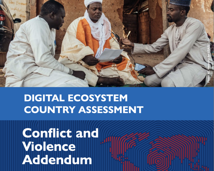 Three people sitting down and looking at a document. Cover photo for the Digital Ecosystem Country Assessment Conflict and Violence Addendum.
