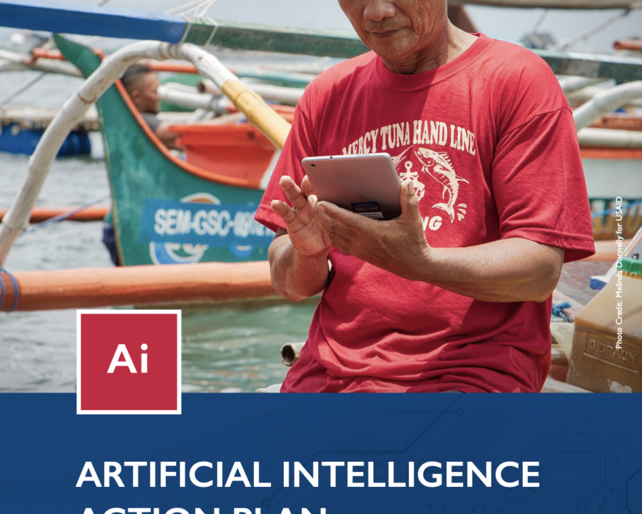A man looking at his device while on a boat. Cover photo for the USAID Artificial Intelligence Action Plan.